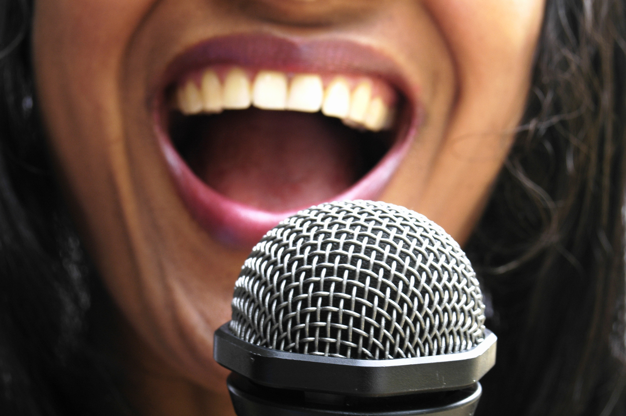 A woman singing with the focus on the microphone; who was The Supremes' first singer?