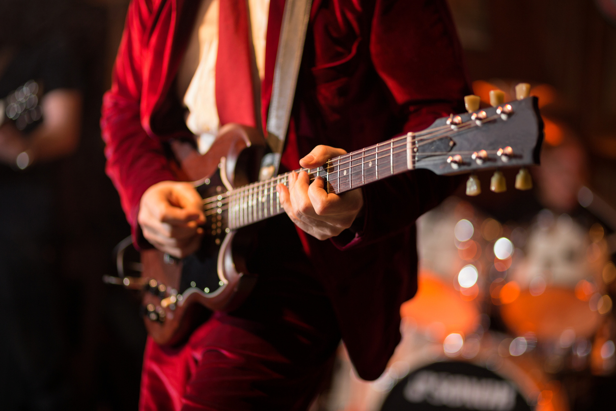Man in a red suit playing electric guitar. What is Skiffle?